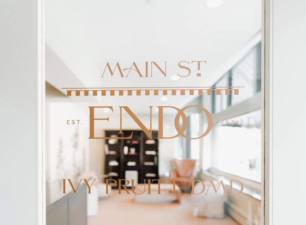Minimalist medical office corridor with glass panels and copper-toned lettering.