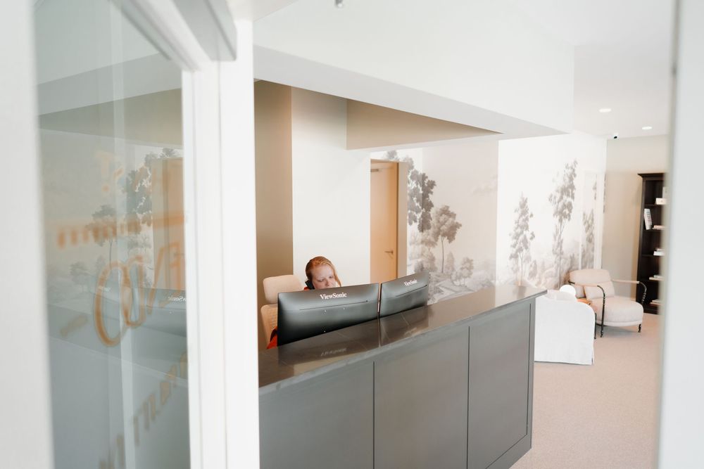 Modern medical facility reception area with sleek grey cabinetry and frosted glass details.