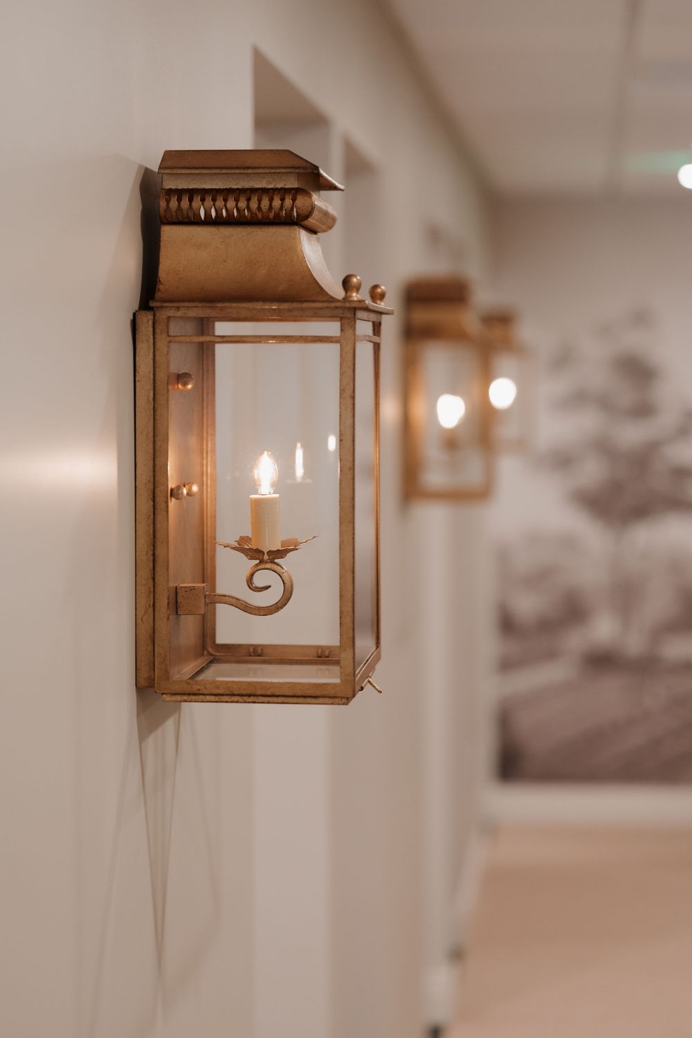 Vintage-style wooden wall sconce with glass panels in warm lighting.