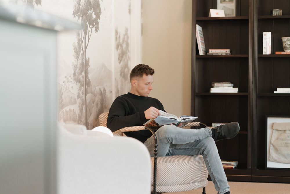 Interior waiting area with modern furniture and decorative wall mural.