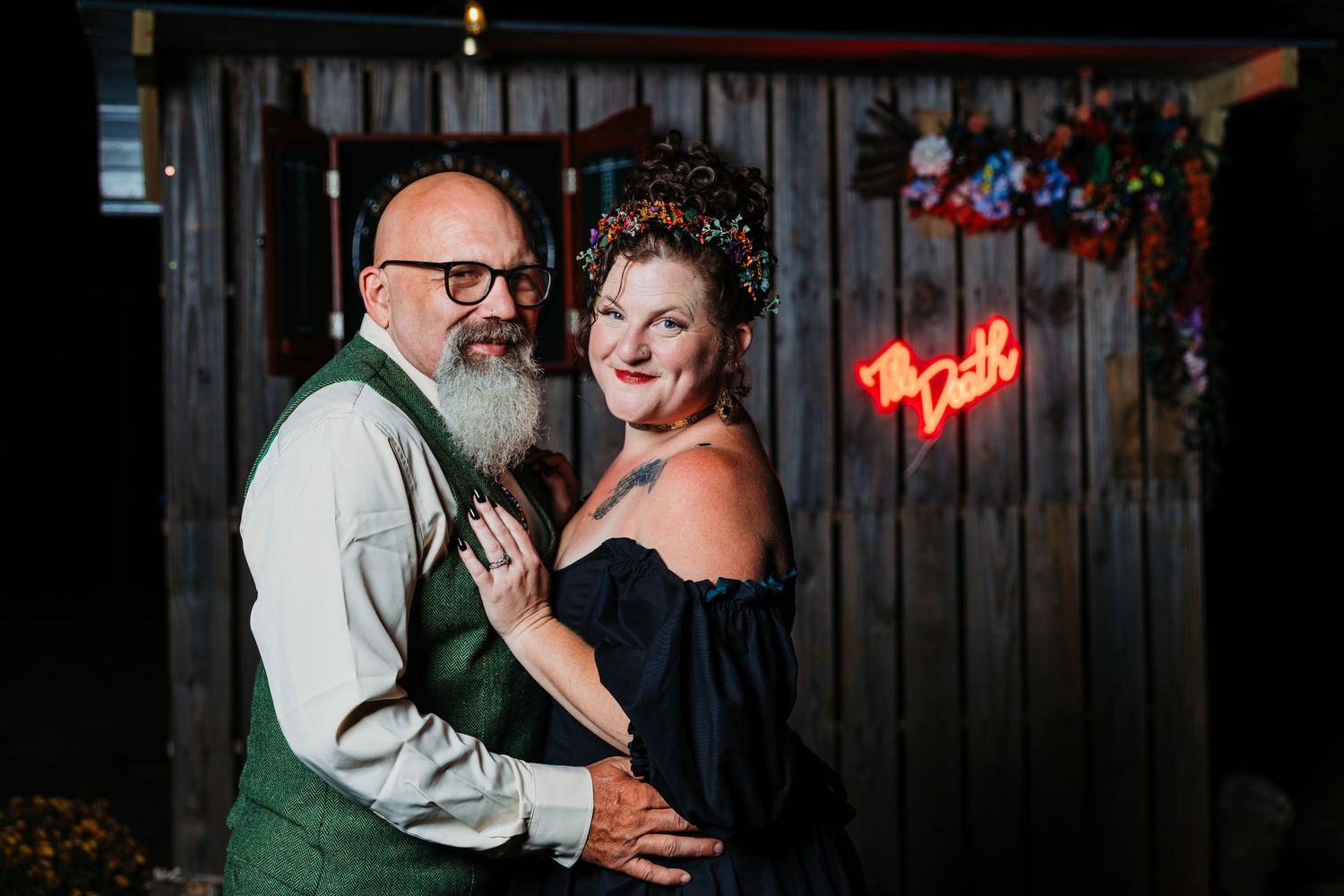 A couple shares an intimate dance moment together during a wedding reception at a rustic venue with string lights.