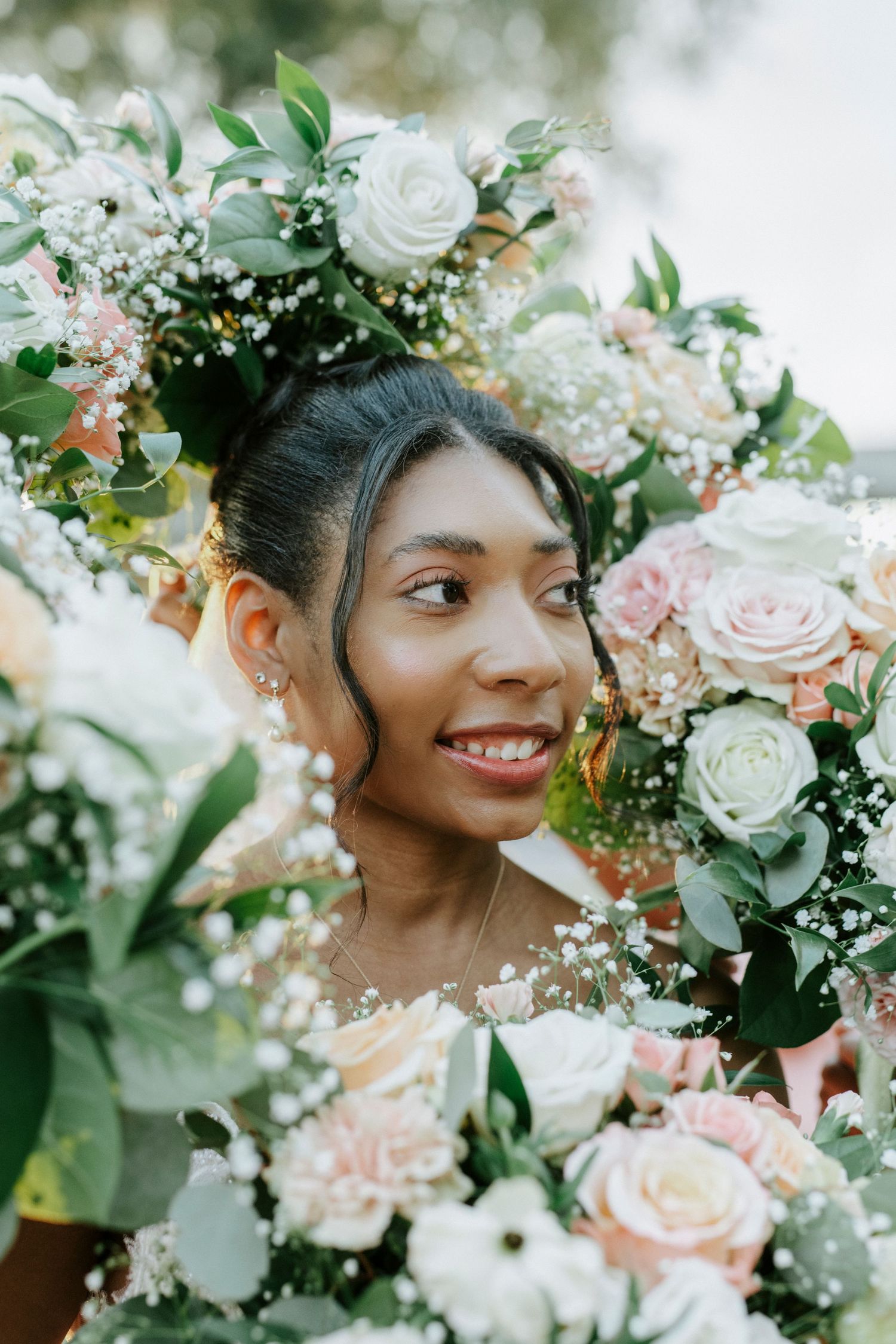 Delicate floral arrangements featuring white and blush roses with greenery for a romantic wedding.