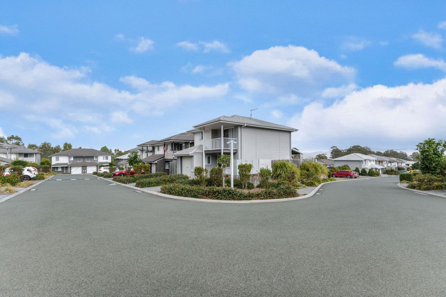Modern townhouse complex on a quiet suburban street, captured for real estate marketing in the Gold Coast and Brisbane region.