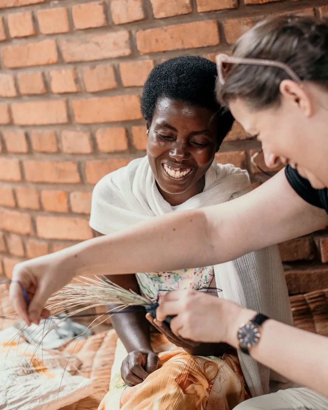 Two women prepare food together and smile, showing teamwork, connection and shared moments in the kitchen.