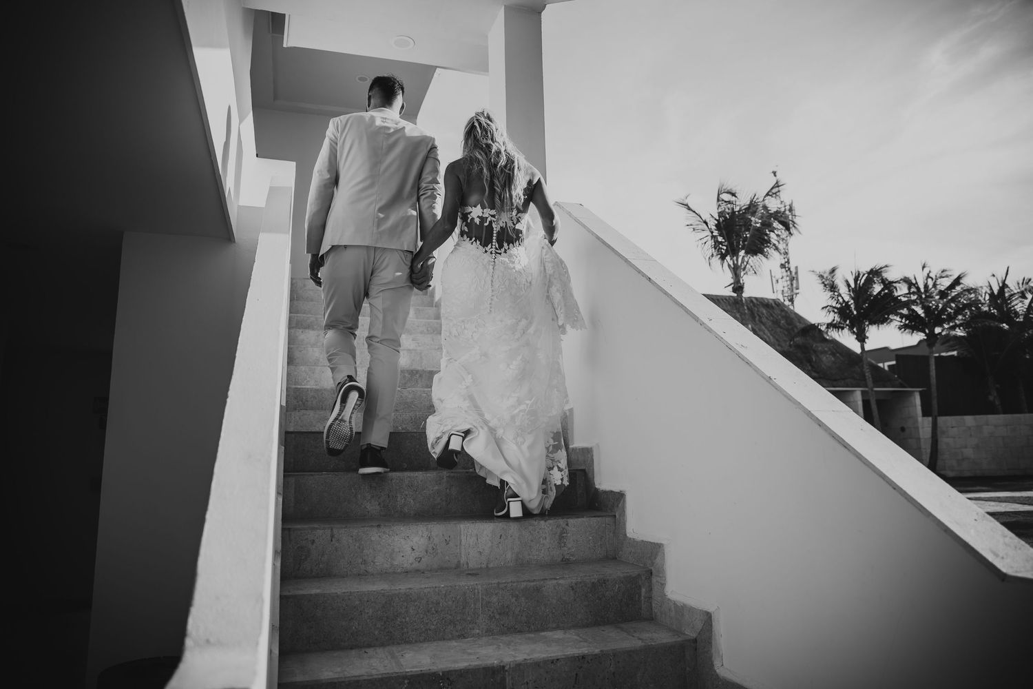 A black and white photo series showing people walking up a staircase with dramatic shadows and lighting.Dreams Sapphire Riviera Maya Wedding