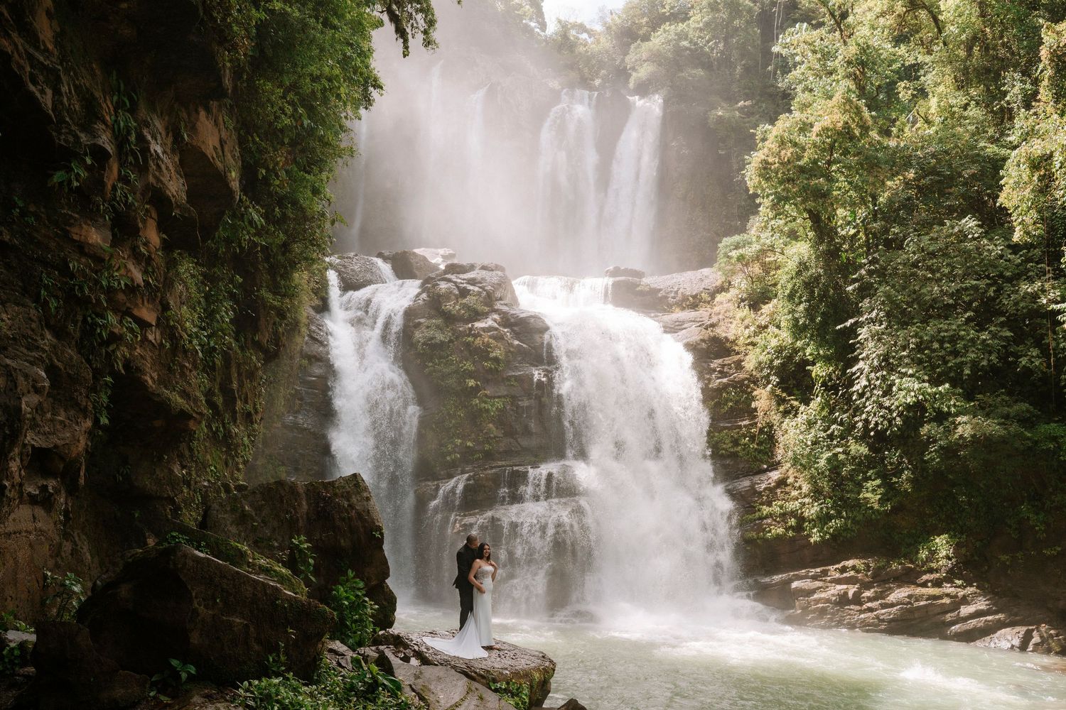 Couple standing in front of Nauyaca Waterfall during their Costa Rica adventure session.