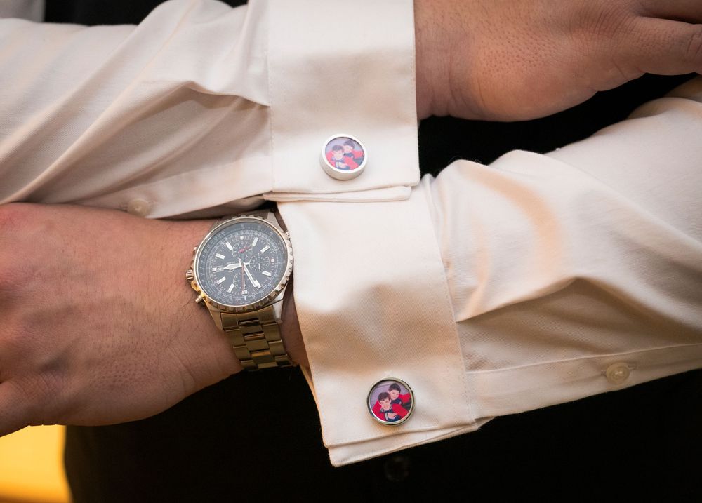 Close-up shots of formal white shirt cuffs with various cufflinks being fastened in sequence.
