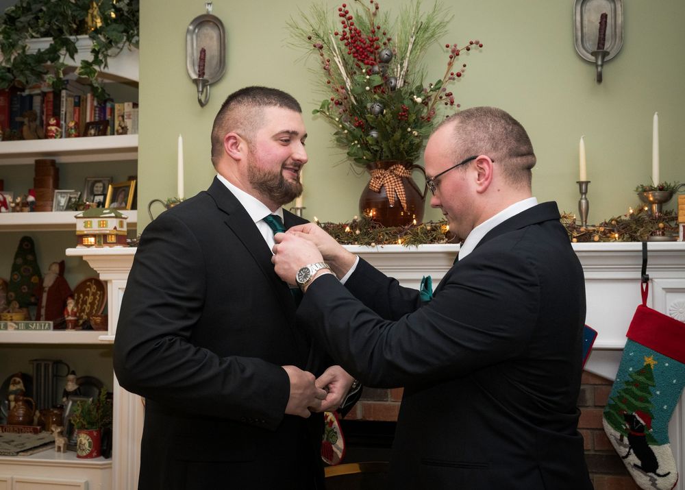 Wedding party members in formal attire sharing a celebratory moment indoors.
