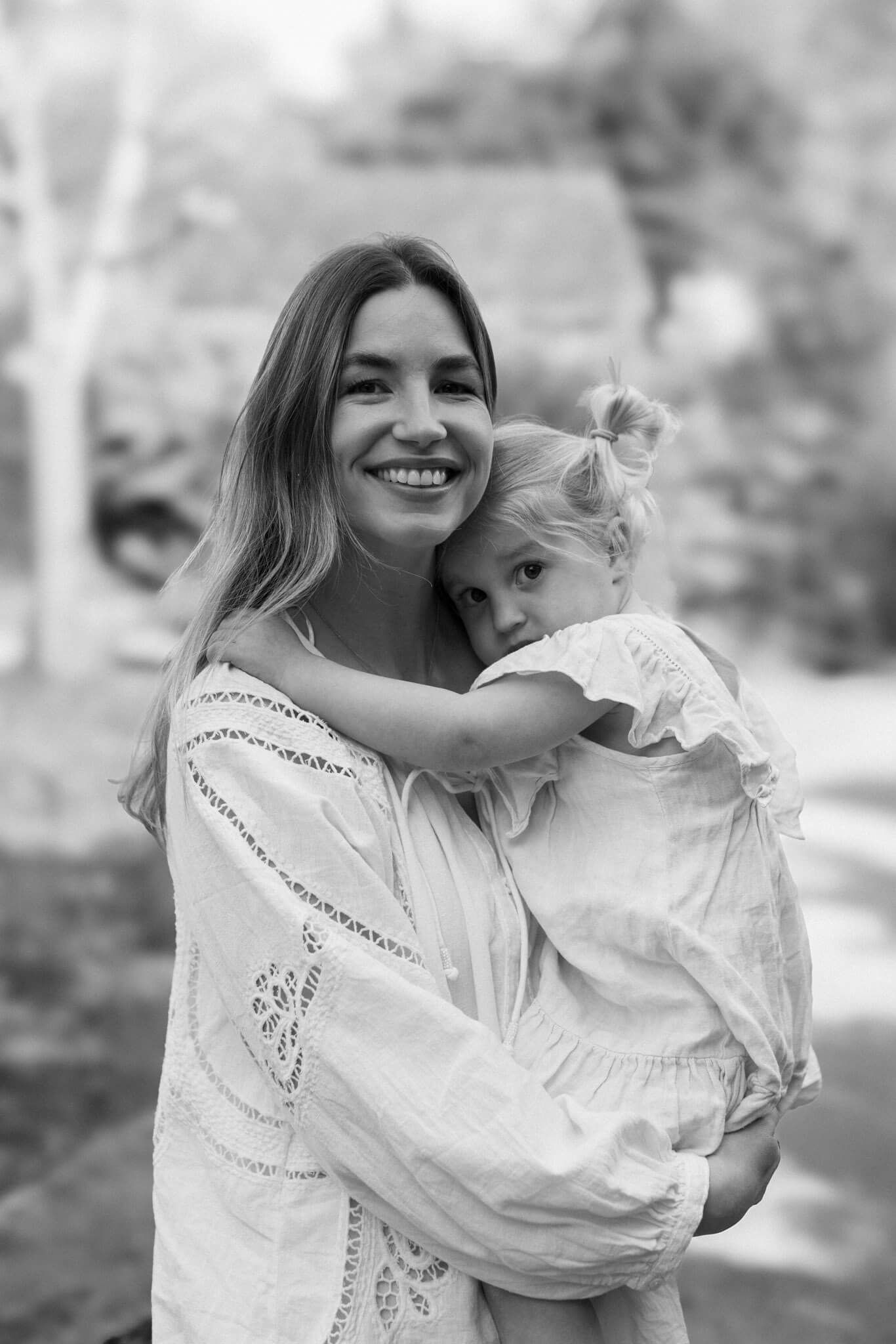 Black and white photo of a mother holding her daughter during an outdoor family photography session in Brighton