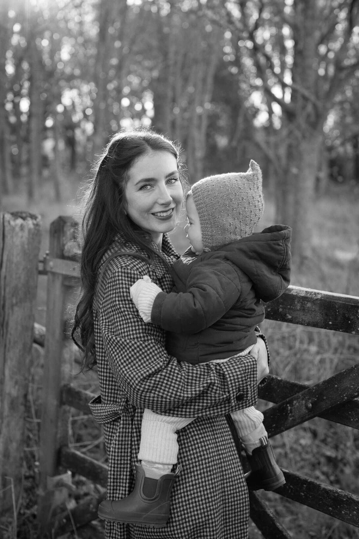 Mother holding her baby in woodland in Sussex during an outdoor family photography session