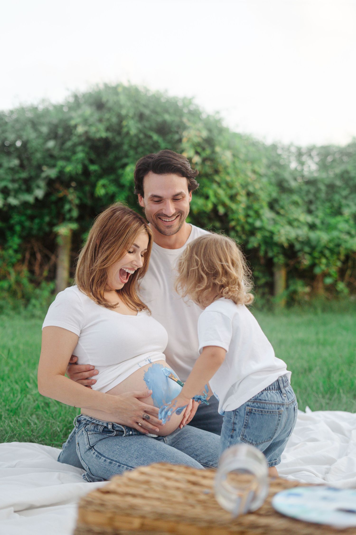 Maternity session outdoors with siblings, playful paint, colorful family photos, natural light, candid moments, lifestyle photography.