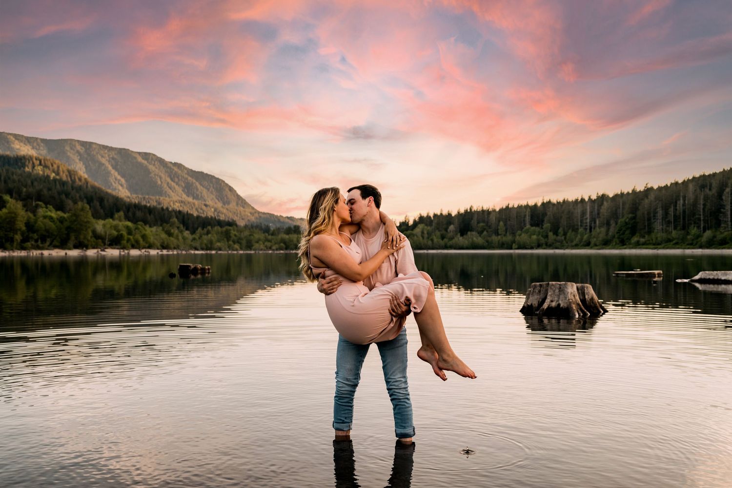 Couple holding each other in the water at Rattlesnake Lake sharing a kiss for engagement photos