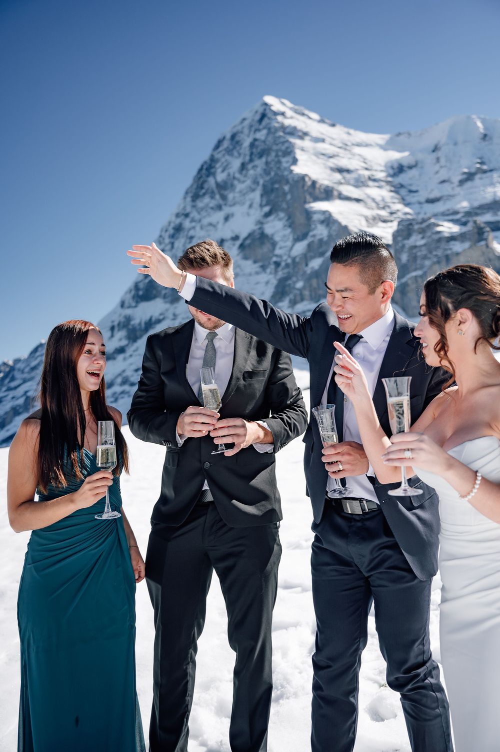 Wedding party celebrates with champagne against snowy mountain backdrop in a playful sequence.