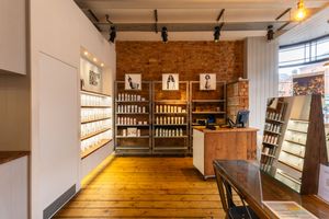 Long wooden hallway with warm lighting features rustic beams and wall-mounted wine storage displays in a cellar setting.