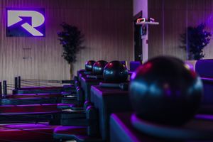 A dark street illuminated by purple and blue neon lights with a cyberpunk aesthetic.