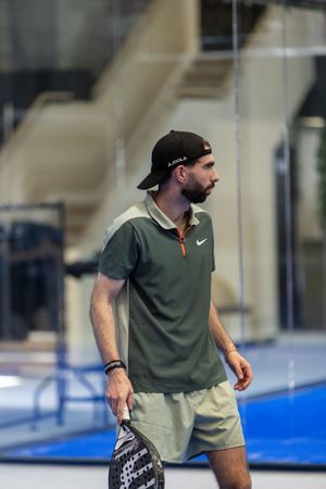 Athletic player moving on a bright blue indoor court surface during practice or training.