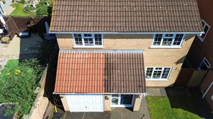 Aerial view of residential houses with brown roofs and well-maintained lawns in a suburban neighborhood.
