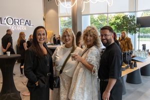 Professionals network and mingle at a L'Oreal corporate event in a modern office space.