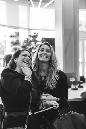 A series of black and white photos showing two people laughing together in a candid moment.