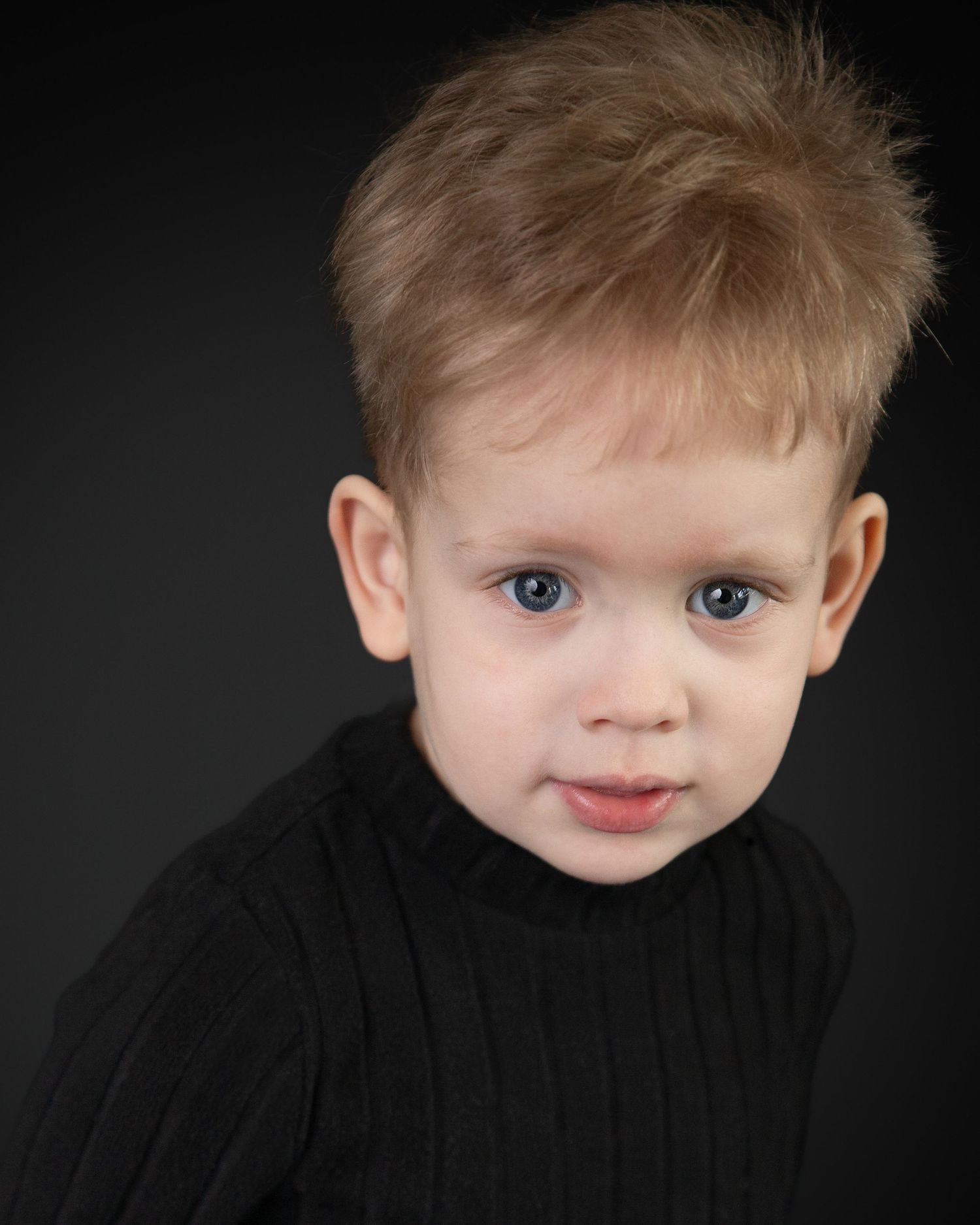 A child wearing a lavender t-shirt poses with windswept hair and playful expressions in a series of headshots.