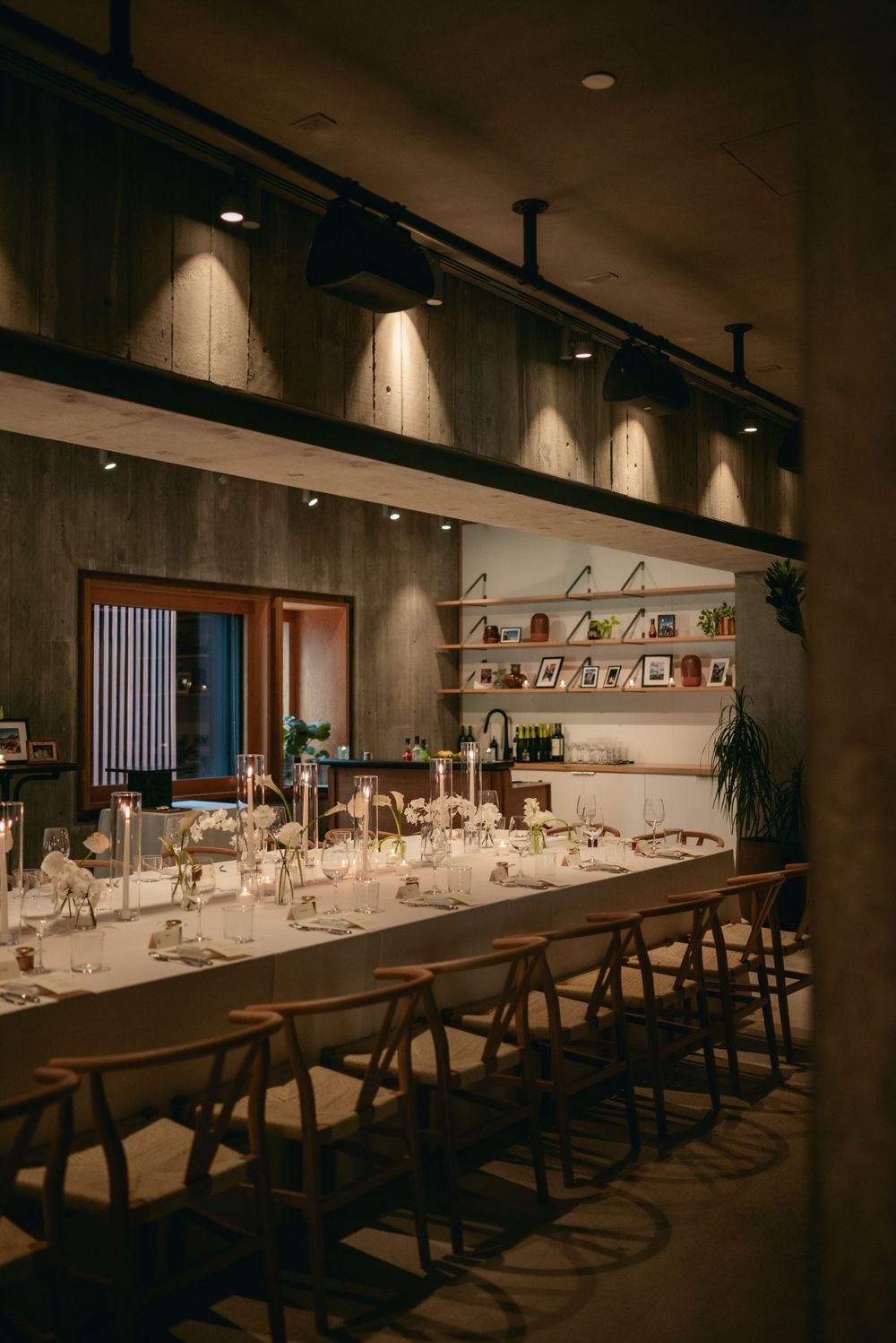 Long dining tables set for an elegant wedding reception with modern minimalist decor.