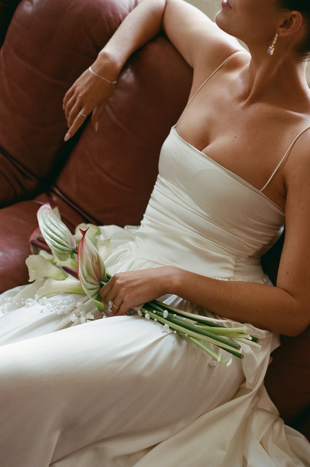 Detail shot of white wedding dress fabric with delicate floral elements.