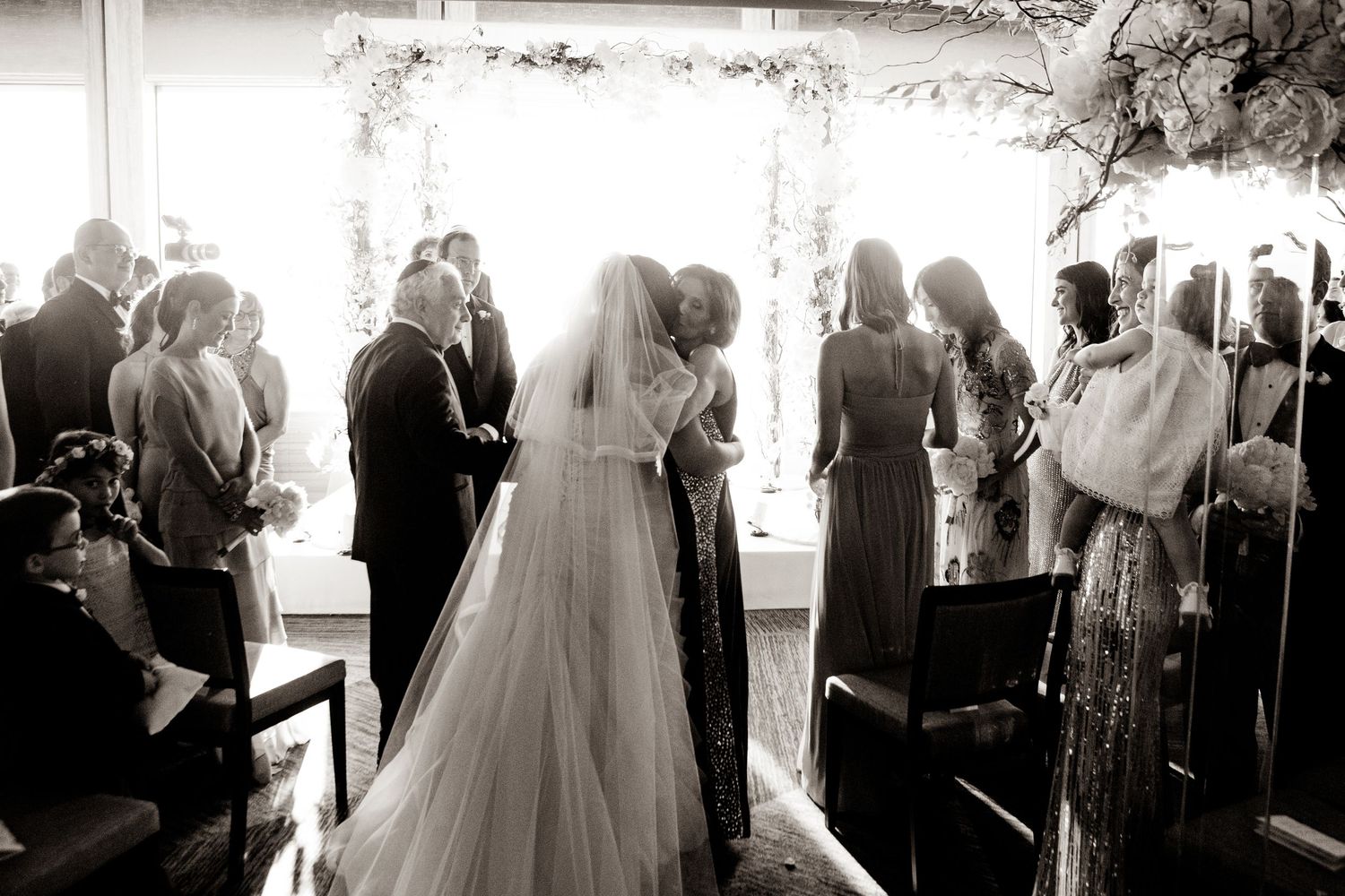 Black and white wedding ceremony photos arranged in a filmstrip style sequence showing guests and celebrations.