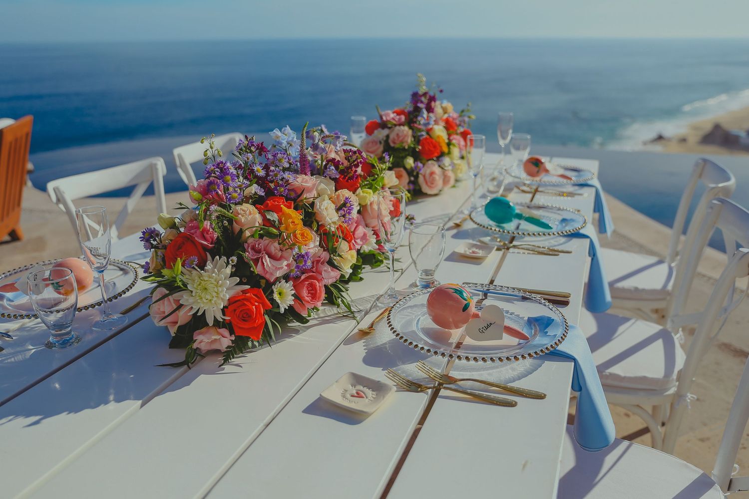 Elegant wedding reception tables set with colorful floral Pedregal Los Cabos Wedding Photographer