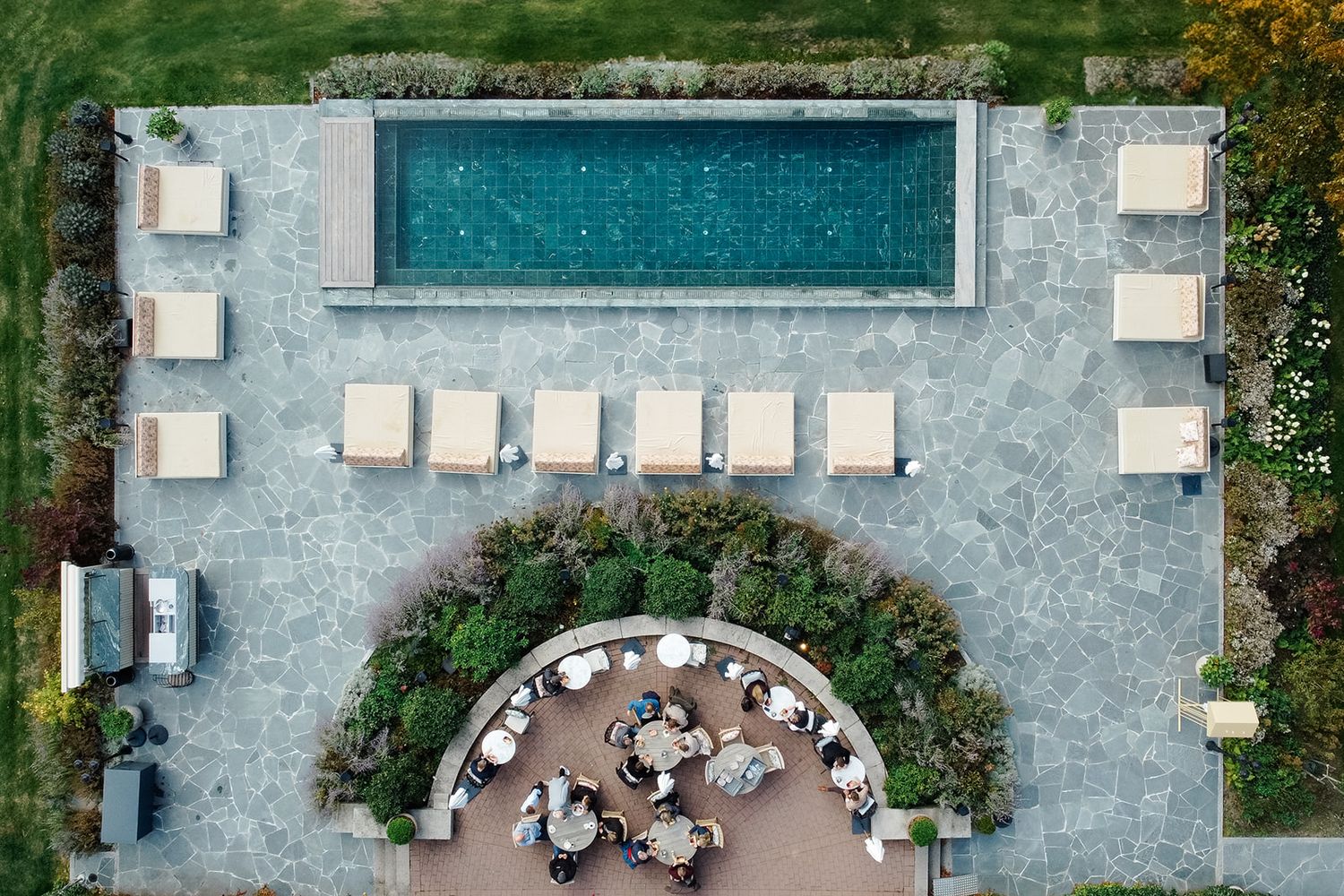 Aerial view of a modern rectangular swimming pool with lounge chairs and landscaping on a luxury property.