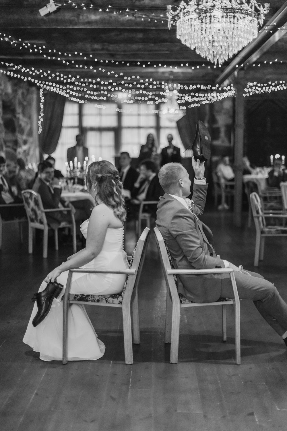 A black and white photo series showing guests lounging in chairs at a wedding reception under string lights.