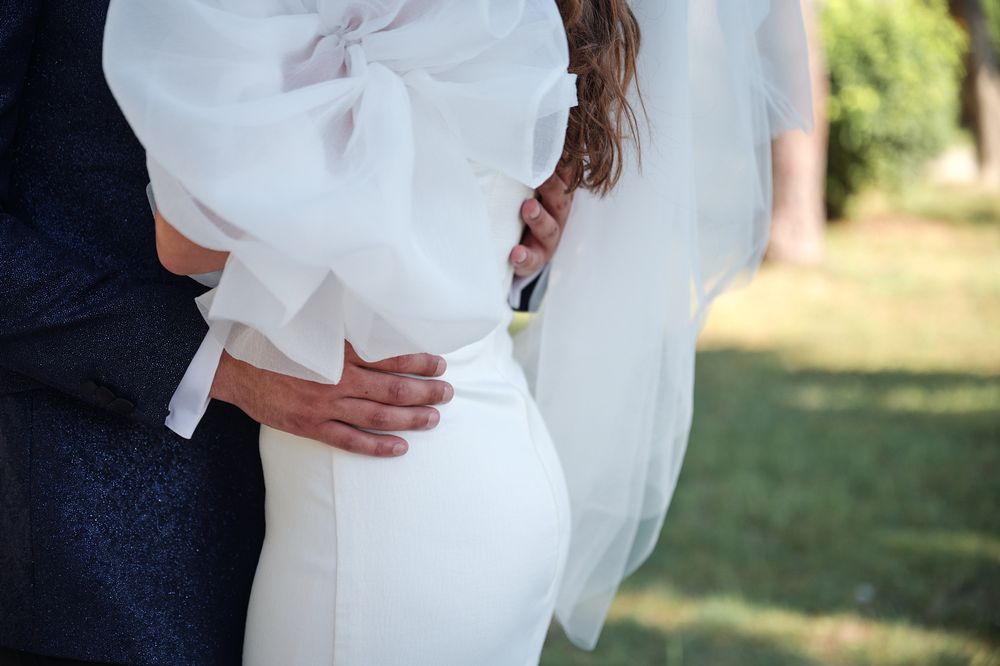 Close-up detail of elegant white wedding dress fabric and formal attire.