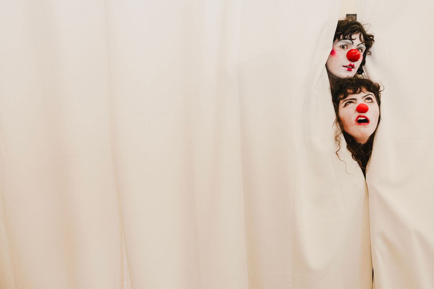 A series of four photos showing someone wearing a red clown nose and making different playful expressions.