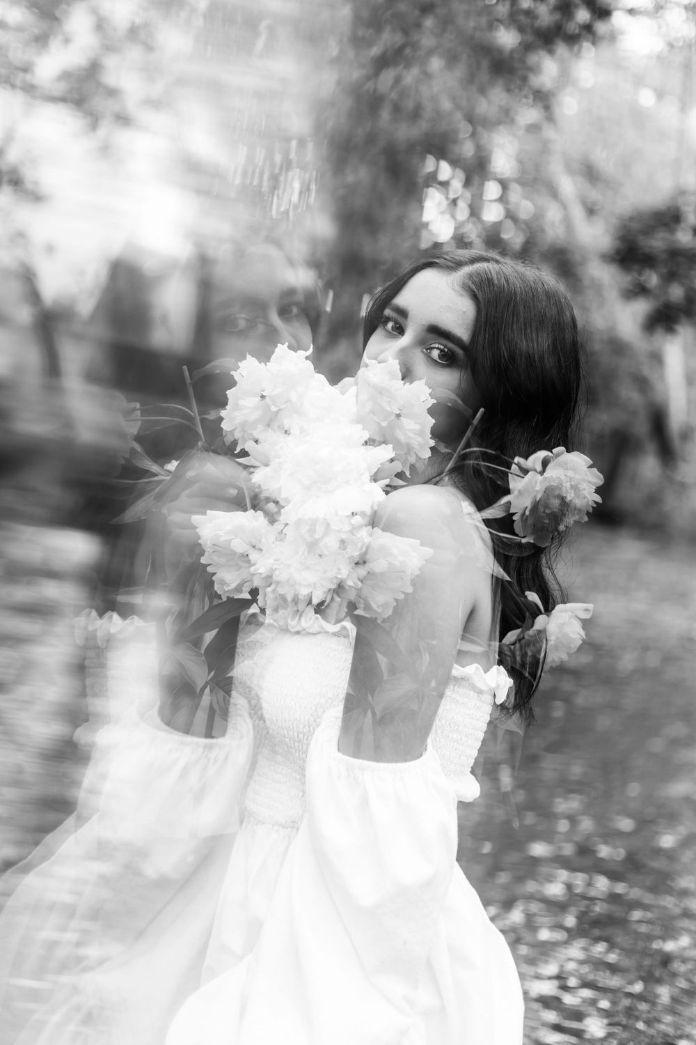 Dreamy double exposure bridal portrait with soft bokeh and delicate white flowers.