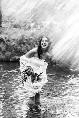 Black and white sequence of someone in white clothing playing in a stream or creek.