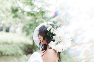 Artistic spring portrait with white magnolia blooms and soft bokeh lighting effects.