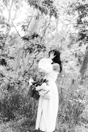 A dreamy black and white photo sequence shows a figure in white dress moving through a forest setting.