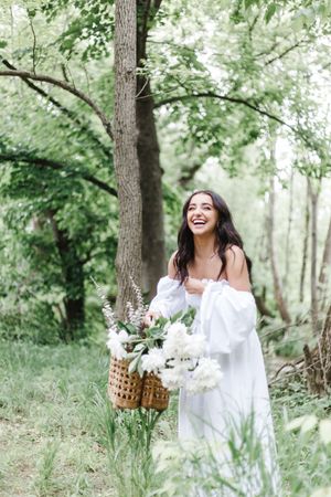 Whimsical forest photography with woven baskets of white flowers and natural greenery.