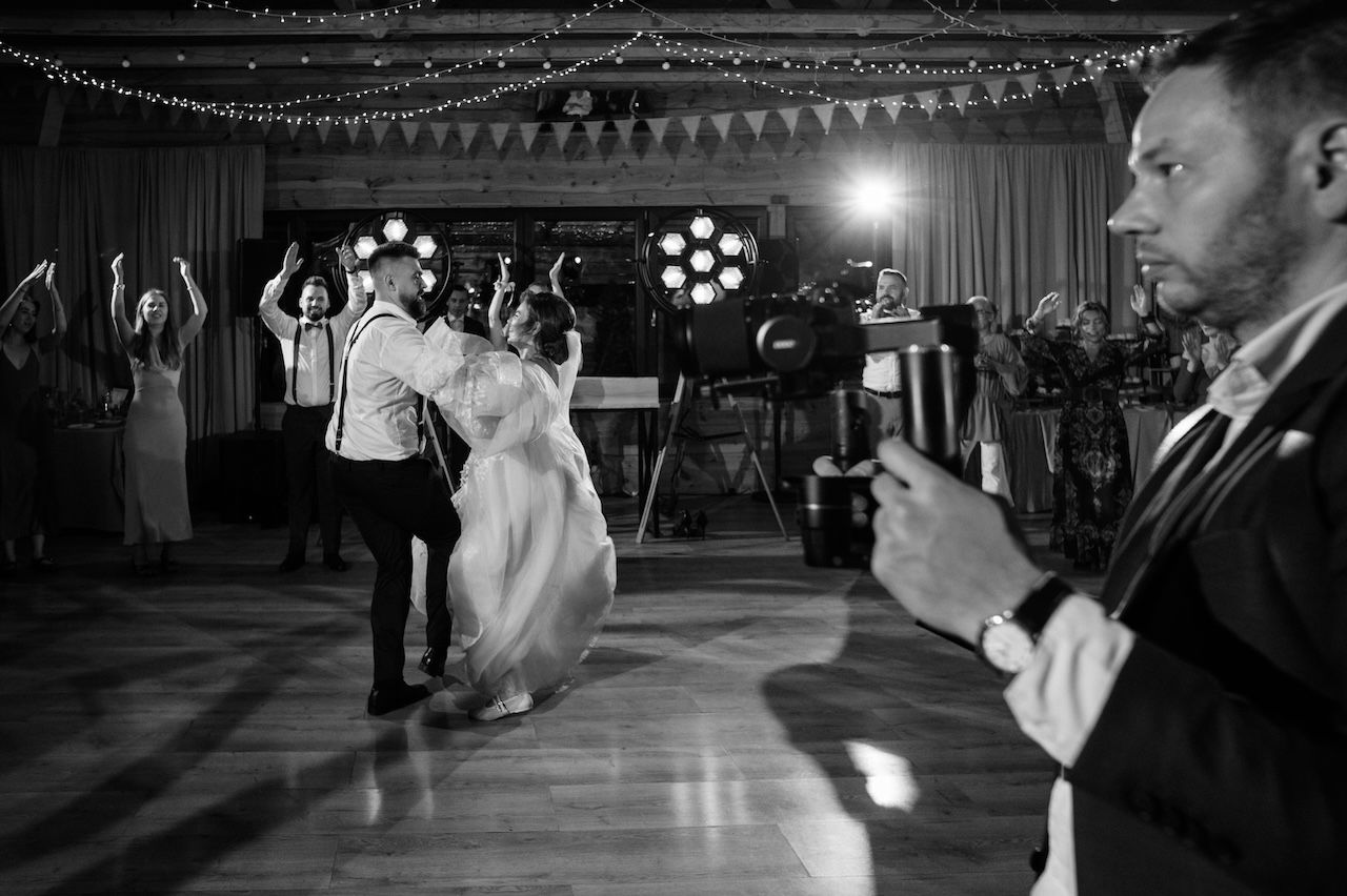 Black and white photo of bride and groom sharing first dance at wedding reception.