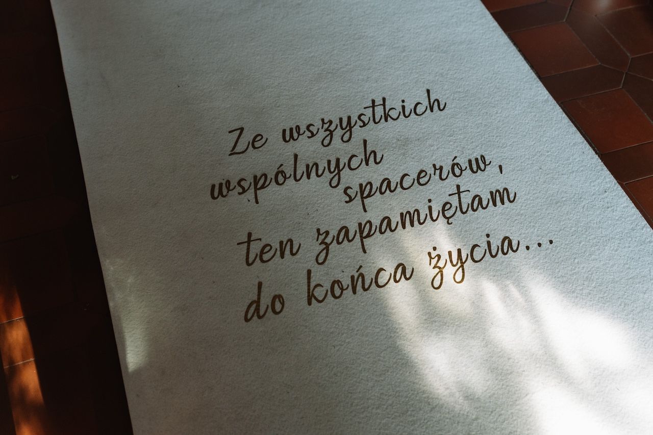 Wedding aisle runner with Polish inscription reading a romantic quote in elegant gold lettering.