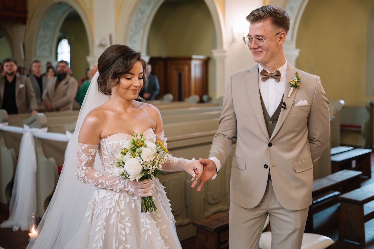 Bride and groom walking hand in hand down the church aisle after wedding ceremony.