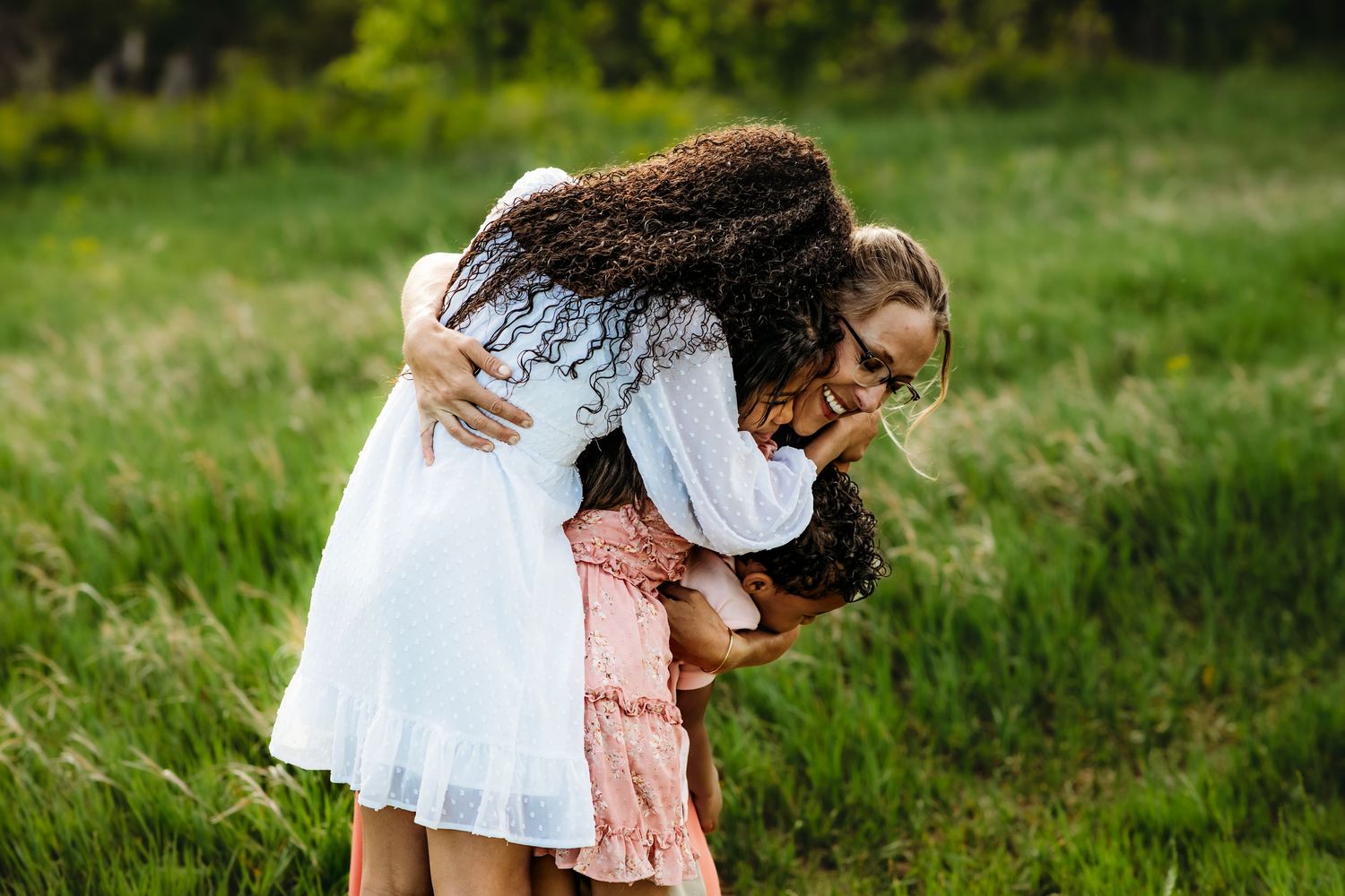 A series of intimate outdoor photos showing tender moments between two people in a lush green field.