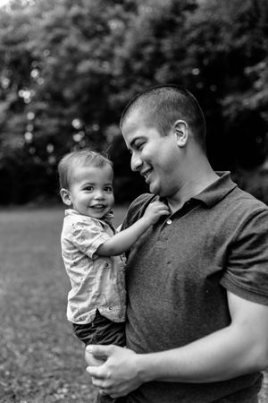 A heartwarming black and white sequence shows a parent and baby sharing joyful moments together outdoors.