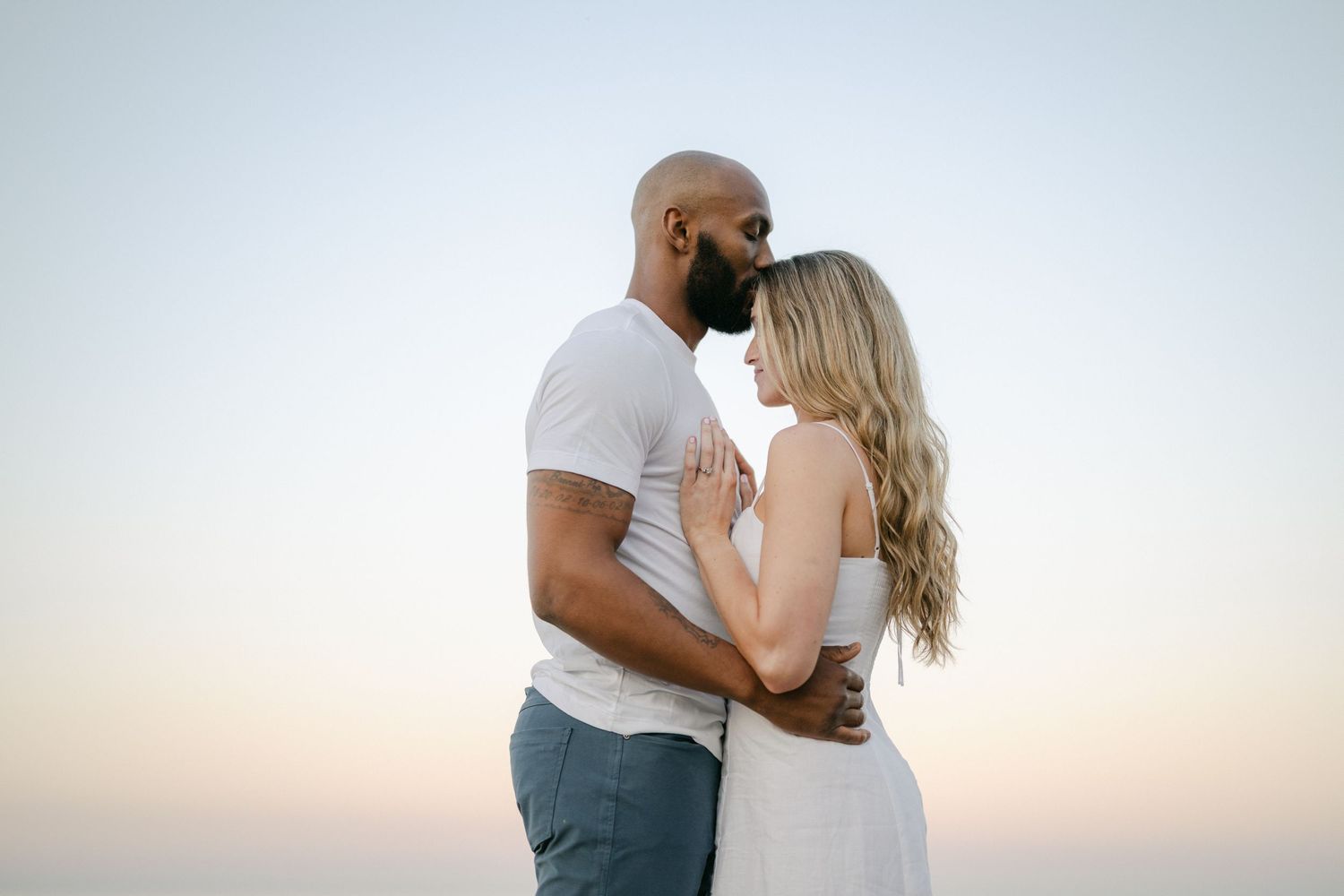 A romantic black and white photo series showing intimate moments between a couple against a white backdrop. - Lake Forest