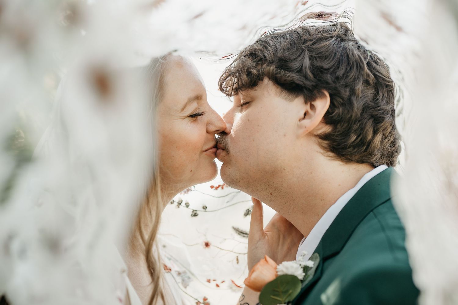 Close-up of wedding rings and hands with elegant jewelry as couple shares intimate moment in formal attire.
