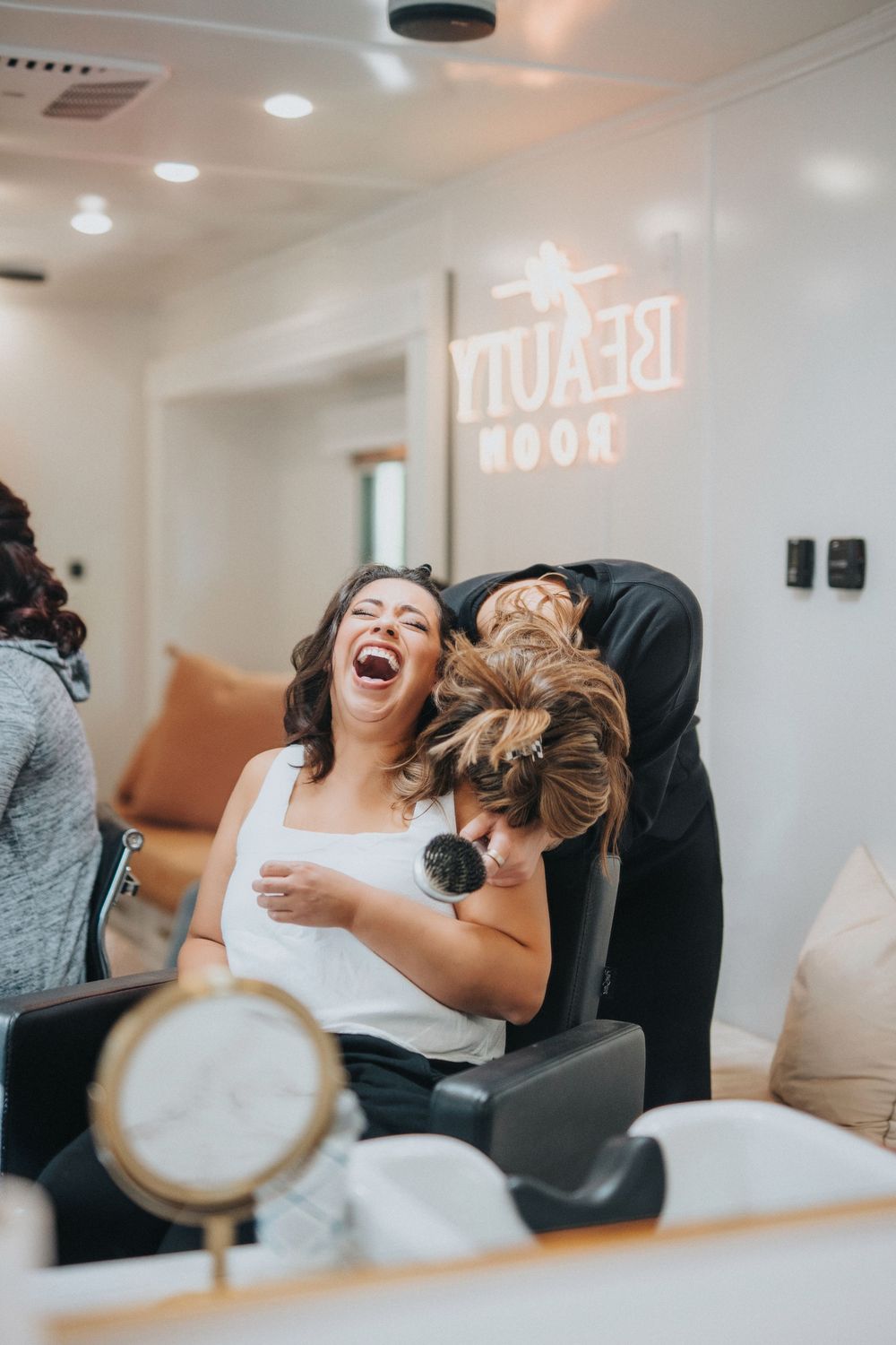 Joyful moments captured in modern white room with neon signs.
