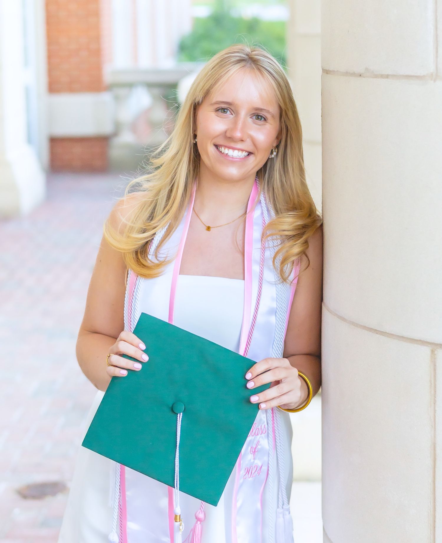 College graduate smiling from ear to ear as she prepares for her graduation