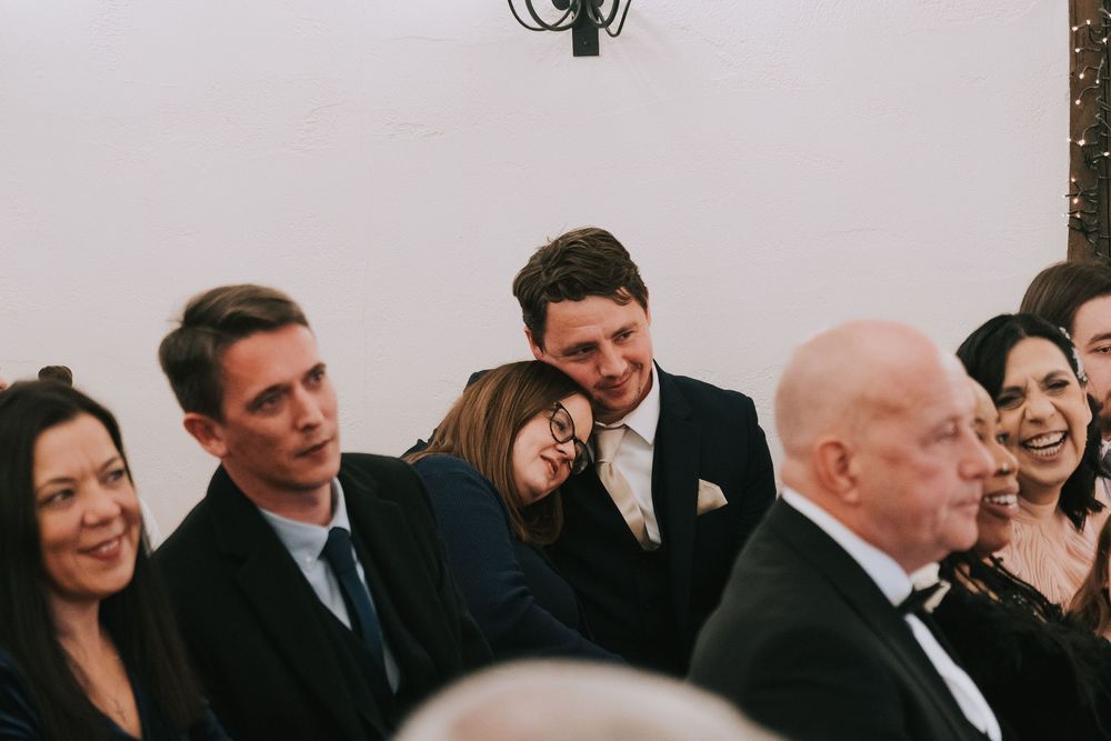 A crowd of formally dressed guests gather and socialize at an elegant indoor event.