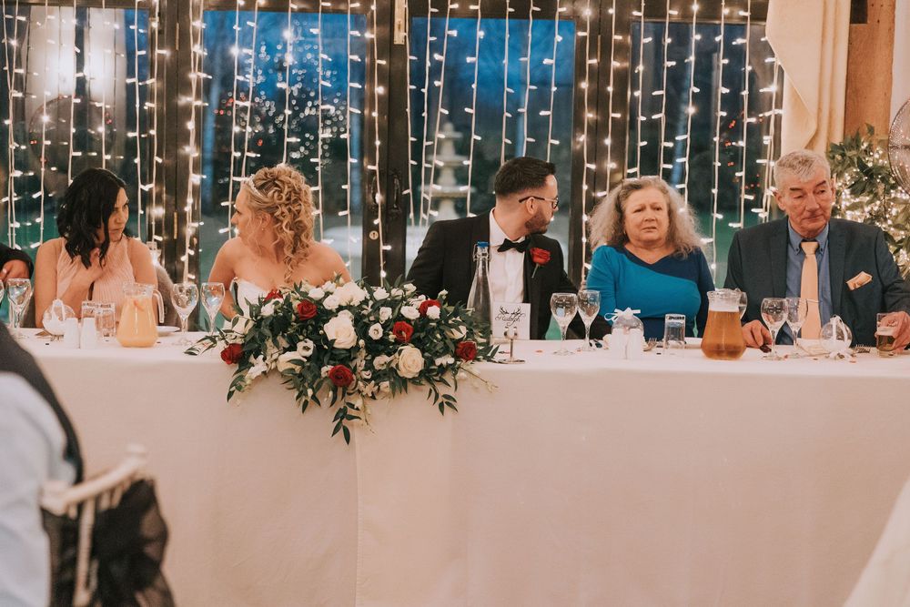 Elegant wedding reception venue adorned with string lights and holiday greenery creating a magical atmosphere.