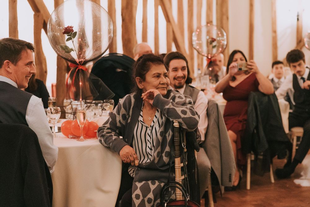 Wedding guests dance and celebrate on a rustic wooden barn dance floor during an evening reception.