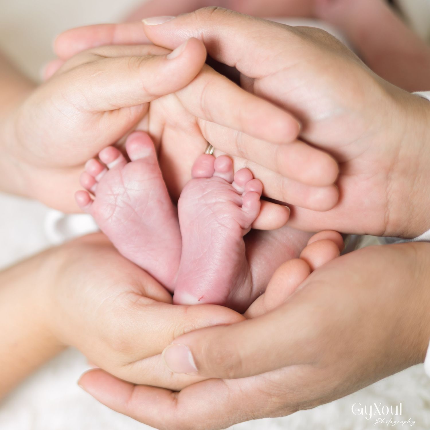 Gentle hands cradle tiny newborn baby feet in a tender moment of care and connection.